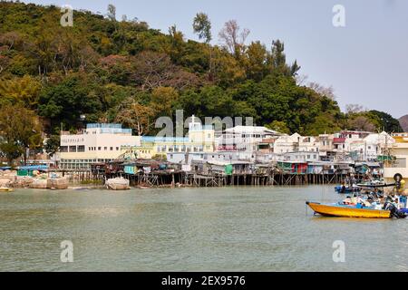 Barche e tradizionali case in palafitte lungo il fiume Tai o nel villaggio di pescatori di Tai o, Lantau, Hong Kong. Foto Stock