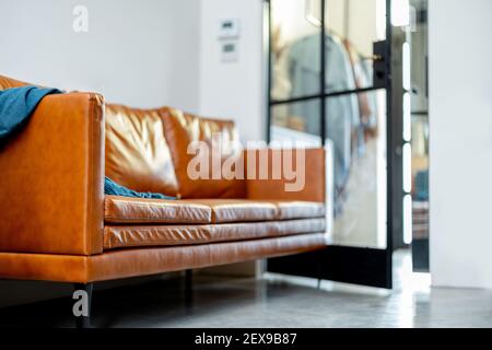 Divano in pelle marrone nel soggiorno in bella casa interna. Concetto di stile di vita. Foto Stock