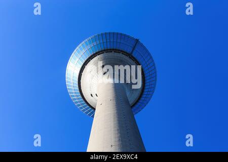 Düsseldorf (Rheinturm), Germania - 1 marzo. 2021: Vista ad angolo basso oltre l'alta torre di cemento sulla piattaforma di osservazione isolata contro lo sk blu scuro senza nuvole Foto Stock