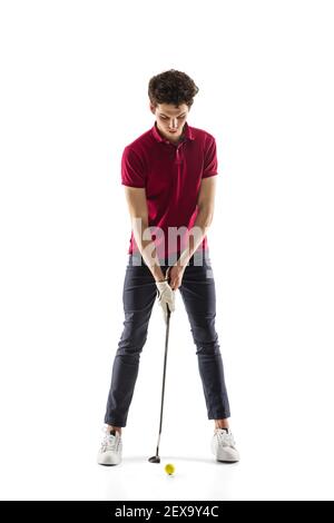 Obiettivo. Giocatore di golf in una camicia rossa isolata su sfondo bianco studio con copyspace. Giocatore professionista che pratica con emozioni ed espressione facciale. Sport, movimento, concetto di azione. Foto Stock