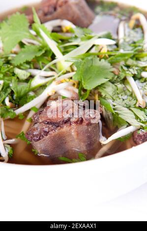 Un colpo di fuoco selettivo della zuppa di pho vietnamita di osscoda con coriandolo Foto Stock