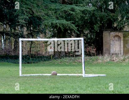 Piccolo 5 un posto di obiettivo laterale con una palla a terra con alberi sullo sfondo. Foto Stock