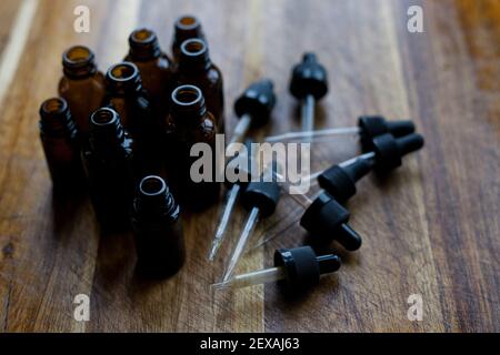 Una collezione di bottiglie contagocce color ambra su sfondo di legno Foto Stock