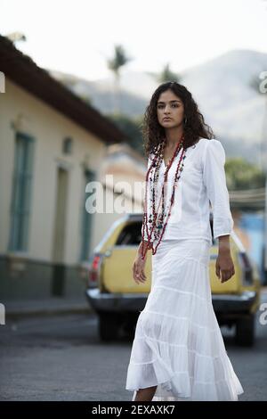 Giovane donna da lungo ghepardo che attraversa la strada nel villaggio di Choroni, Henri Pittier National Park, Venezuela Foto Stock