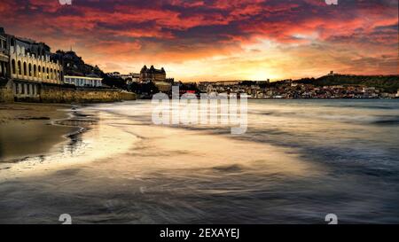 Scarborough Sunrise sulla South Bay e il Castello di Scarborough, Scarborough, North Yorkshire, Regno Unito. Foto Stock