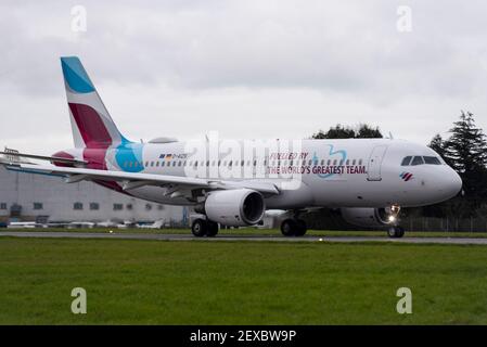 Aeroporto Southend di Londra, Essex, Regno Unito. 4 Marzo 2021. La compagnia aerea tedesca Eurowings ha aggiunto un messaggio a uno dei loro aerei per ringraziare i loro dipendenti per gli sforzi compiuti durante la pandemia di COVID 19. Da una parte ‘alimentata dalla più grande squadra del mondo’ in inglese, e in tedesco dall’altra. L'Airbus A320 è stato volato a Satys Air Livery a Southend per il lavoro e oggi è partito per entrare in servizio. Jens Bischof, CEO di Eurowings: "I nostri dipendenti hanno dimostrato uno spirito di squadra eccezionale durante la crisi. Per questo vogliamo ringraziarvi in modo straordinario». Foto Stock