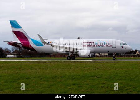 Aeroporto Southend di Londra, Essex, Regno Unito. 4 Marzo 2021. La compagnia aerea tedesca Eurowings ha aggiunto un messaggio a uno dei loro aerei per ringraziare i loro dipendenti per gli sforzi compiuti durante la pandemia di COVID 19. Da una parte ‘alimentata dalla più grande squadra del mondo’ in inglese, e in tedesco dall’altra. L'Airbus A320 è stato volato a Satys Air Livery a Southend per il lavoro e oggi è partito per entrare in servizio. Jens Bischof, CEO di Eurowings: "I nostri dipendenti hanno dimostrato uno spirito di squadra eccezionale durante la crisi. Per questo vogliamo ringraziarvi in modo straordinario». Foto Stock