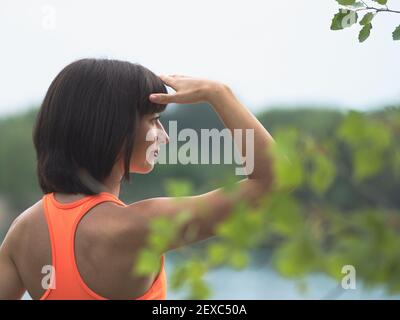 Bella giovane Skinny donna sportiva guardando in lontananza Foto Stock