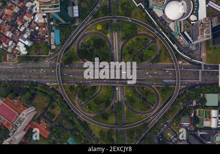Vista aerea dall'alto della grande rotatoria a più corsie di Giacarta, Indonesia, grande incrocio stradale su un'autostrada con traffico automobilistico Foto Stock