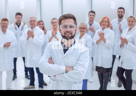 leader scientifico fiducioso che si trova di fronte a un team di giovani scienziati. Foto Stock