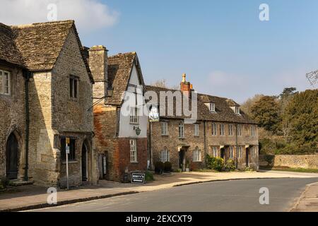 Pittoreschi cottage tradizionali in pietra con terrazza e il George Inn, un pub del villaggio nel villaggio del National Trust di Lacock, Wiltshire, Inghilterra, Regno Unito Foto Stock