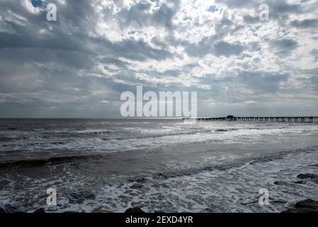 Surf freddo e cielo drammatico durante la giornata invernale a Galveston, Texas, Stati Uniti. Foto Stock