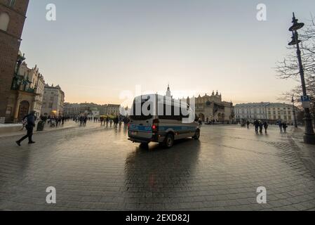 Cracovia, Polonia - 22 febbraio 2021: Un pulmino di polizia in un'immagine panoramica del centro di Cracovia, Piazza principale (Plac Mariacki) e del mercato dell'artigianato Foto Stock