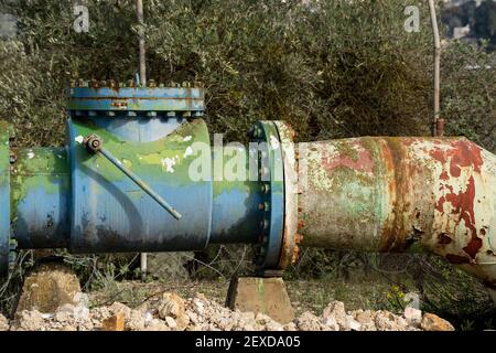 Un vecchio oleodotto arrugginito, la sua vernice si stacca, nei monti della Giudea, vicino a Gerusalemme, Israele Foto Stock