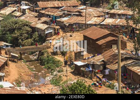 La gente va circa le loro procedure quotidiane di vita in parte della baraccopoli di Kibera a Nairobi, Kenia Foto Stock