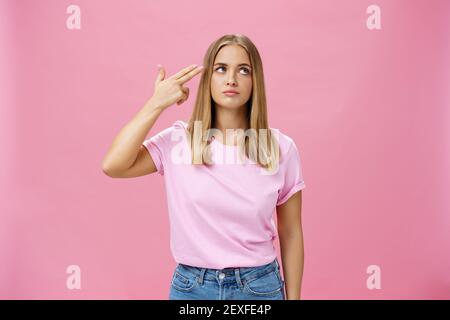 Qualcuno mi uccide per favore. Infastidito e annoiato alimentato cute giovane donna emotiva con pelle abbronzata chubby viso e capelli lisci palpebre che rotola il dito Foto Stock