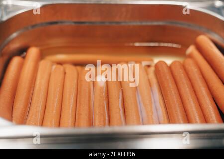 sandwich su un tavolo di legno e salsicce bollite per cucinare hot dog Foto Stock