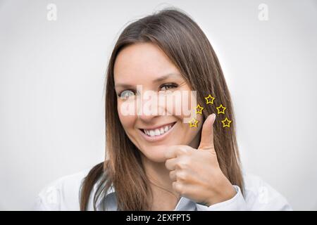 Felice donna di affari sorridente che mostra il pollice su cinque stelle valutazione di qualità. Grande esperienza, concetto di soddisfazione. Foto Stock