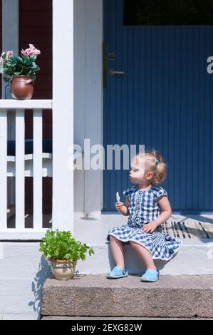 Bella bambina seduta su un gradino Foto Stock