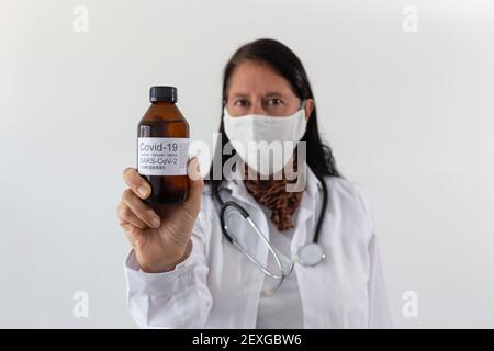 Un medico femminile di mezza età che tiene una bottiglia di vaccino per Coronavirus Covid-19 Foto Stock