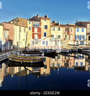 Foto idilliaca di un piccolo porto di Martigues vicino a Marsiglia chiamato specchio d'uccello con case colorate e piccole barche che riflettono acceso Foto Stock