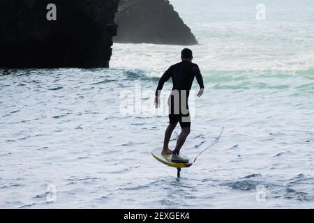 Vista su un maneggio in foilboard (aliscafo) alla spiaggia di Piha, Auckland, Nuova Zelanda Foto Stock