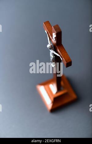 Crocifisso di legno di Gesù Cristo. Sfondo scuro. Messa a fuoco selettiva. Primo piano. Foto Stock