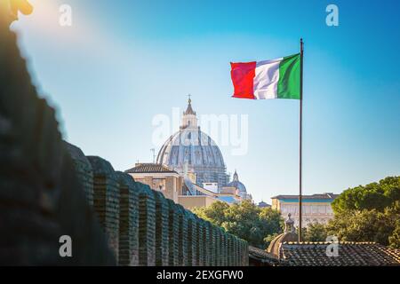 Vista sulla basilica di San Pietro in Vaticano e bandiera italiana sventolante. Foto Stock