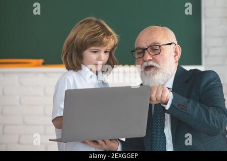 Allievo e insegnante senior in classe. Concetto di istruzione. Concetto di apprendimento scolastico. Scuola elementare ragazzo. Foto Stock