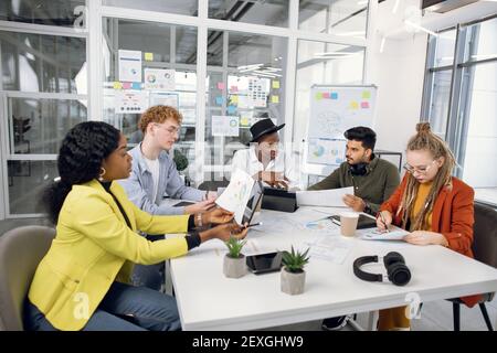 Diversi specialisti IT si riuniscono in ufficio per le riunioni Foto Stock