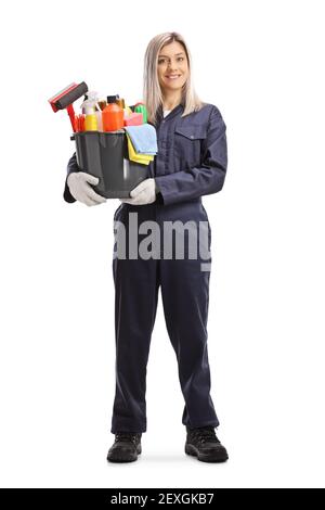 Ritratto a lunghezza intera di un pulitore professionale femmina che tiene un secchio con materiale di pulizia isolato su sfondo bianco Foto Stock