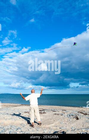 Volare un aquilone sulla spiaggia Foto Stock