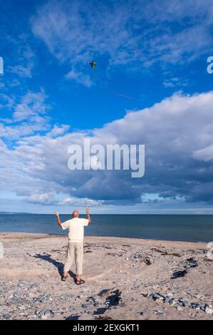 Volare un aquilone sulla spiaggia Foto Stock