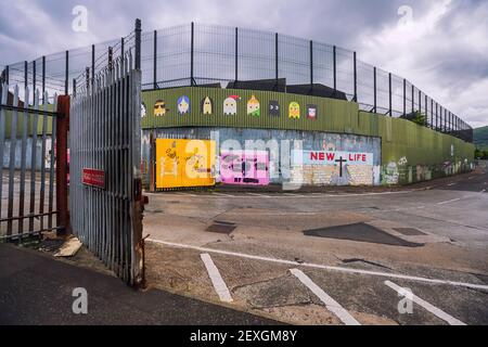 Porta aperta di fronte a uno dei Peace Wall a Belfast, Irlanda del Nord, Regno Unito Foto Stock