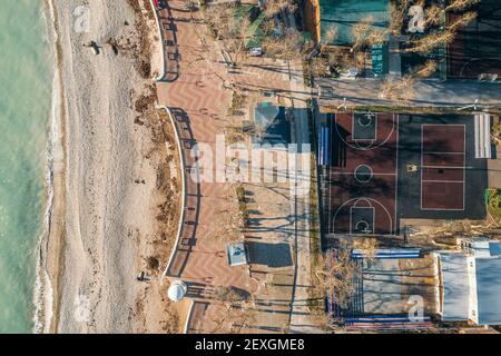 Campo pubblico di pallacanestro sulla costa del mare con area pedonale Vista aerea dall'alto. Foto Stock