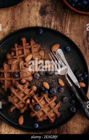 waffle fatti in casa al cioccolato con mirtilli su un bac di legno scuro Foto Stock