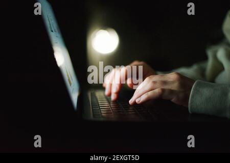 Donna anonima che lavora sul computer portatile di notte Foto Stock