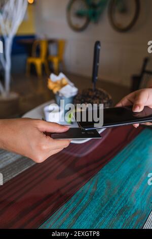 Meno contatti utilizzando lo smartphone con una carta di debito per il pagamento NFC Foto Stock