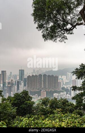 Hong Kong, Cina - 12 maggio 2010: Guardando dal Victoria Peak sul paesaggio urbano di Kwun Tong e Cha Kwo Ling con grattacieli. Cielo stoltico sulla città. Verde Foto Stock