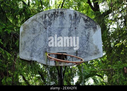 molto vecchio cerchio di pallacanestro abbandonato che sta cadendo a pezzi Foto Stock