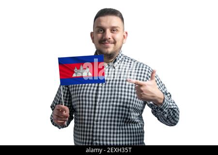 Ragazzo bianco che tiene una bandiera della Cambogia e punta il dito dell'altra mano alla bandiera isolata su uno sfondo bianco. Foto Stock