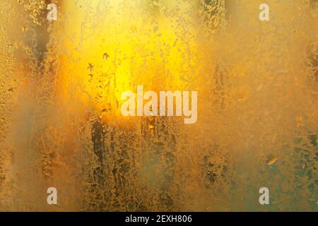 Ghiaccio sul vetro della finestra in luce calda . Superficie di accoppiamento e a freddo Foto Stock