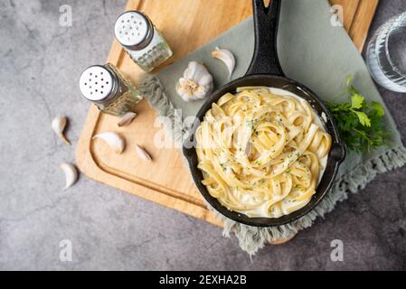 Cena di pasta di Alfredo con salsa bianca cremosa ed erbe aromatiche Foto Stock