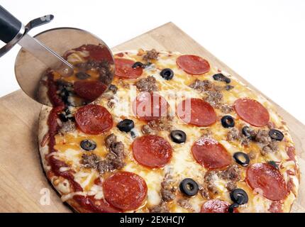 Home appoggiato sul pannello di legno Coltello per affettare la carne Pizza Foto Stock