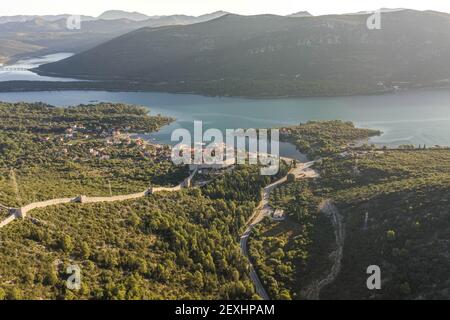 Drone aereo colpo di City Wall di Ston su collina A Mali Ston in Croazia alba estiva Foto Stock