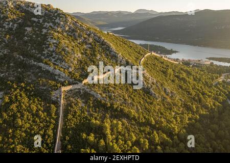 Drone aereo colpo di City Wall di Ston su collina A Mali Ston in Croazia alba estiva Foto Stock