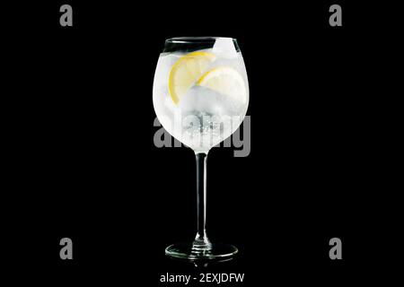 Cocktail a base di gin in bicchiere di vino isolato su sfondo nero. Messa a fuoco selettiva. Profondità di campo poco profonda. Foto Stock