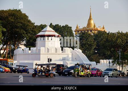 Il traffico passa di fronte al Forte Mahakan e Wat Saket o Golden Mount, Bangkok, Thailandia Foto Stock