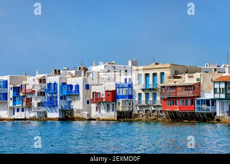 Piccola Venezia sul lungomare della città di Mykonos o Chora, Cicladi, Grecia. Bar, caffè, ristoranti in vecchie case bianche pendono sulle scogliere sopra le onde del mare. Foto Stock