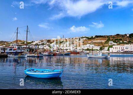 Bella estate nel porto turistico dell'isola greca. Barche da pesca, yacht ormeggiati al molo. Case bianche. Piccola barca blu in primo piano. Mykonos, Grecia. Foto Stock